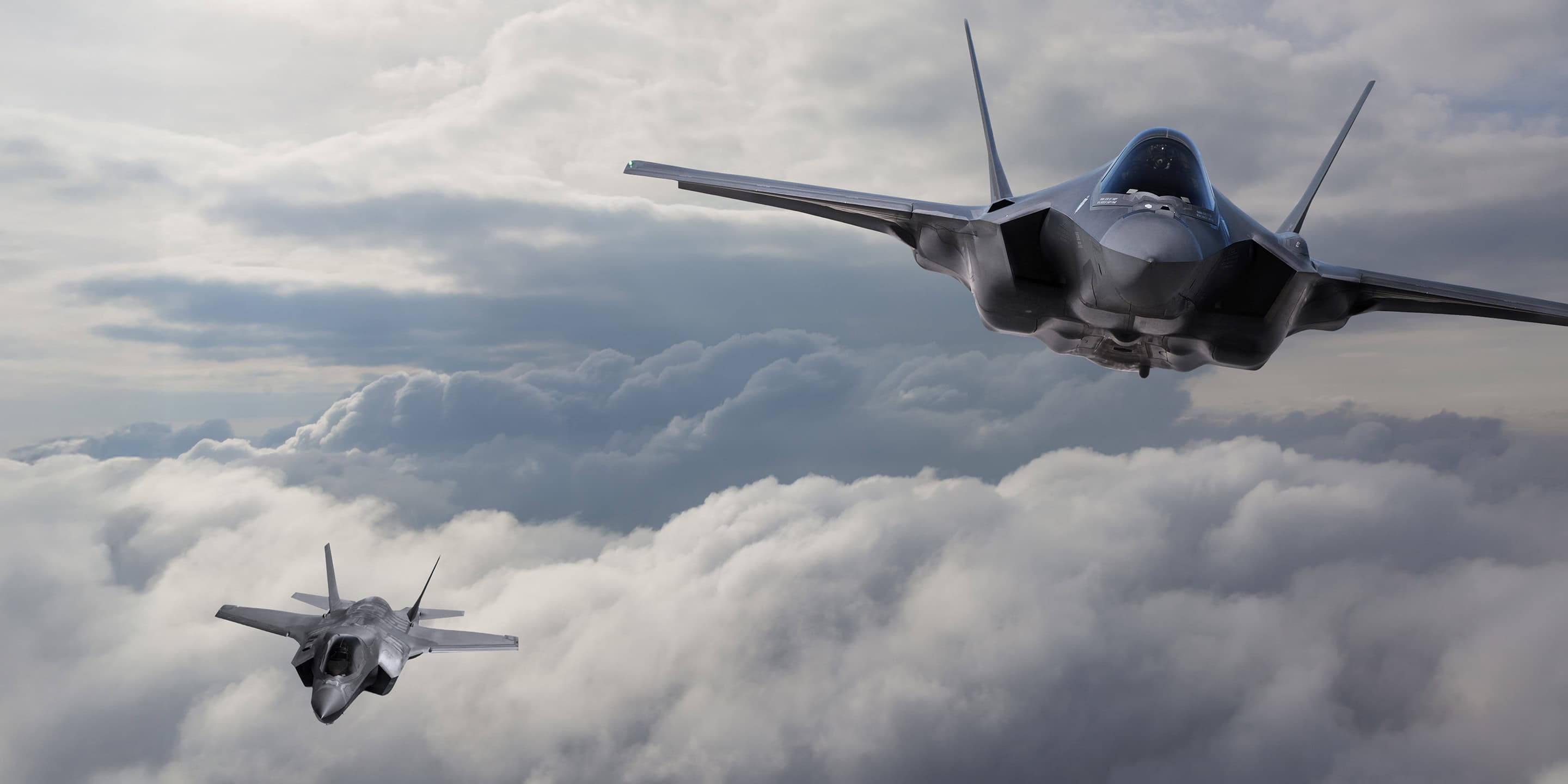 Pair of F-18 Hornet aircraft soaring through the sky in synchronized flight